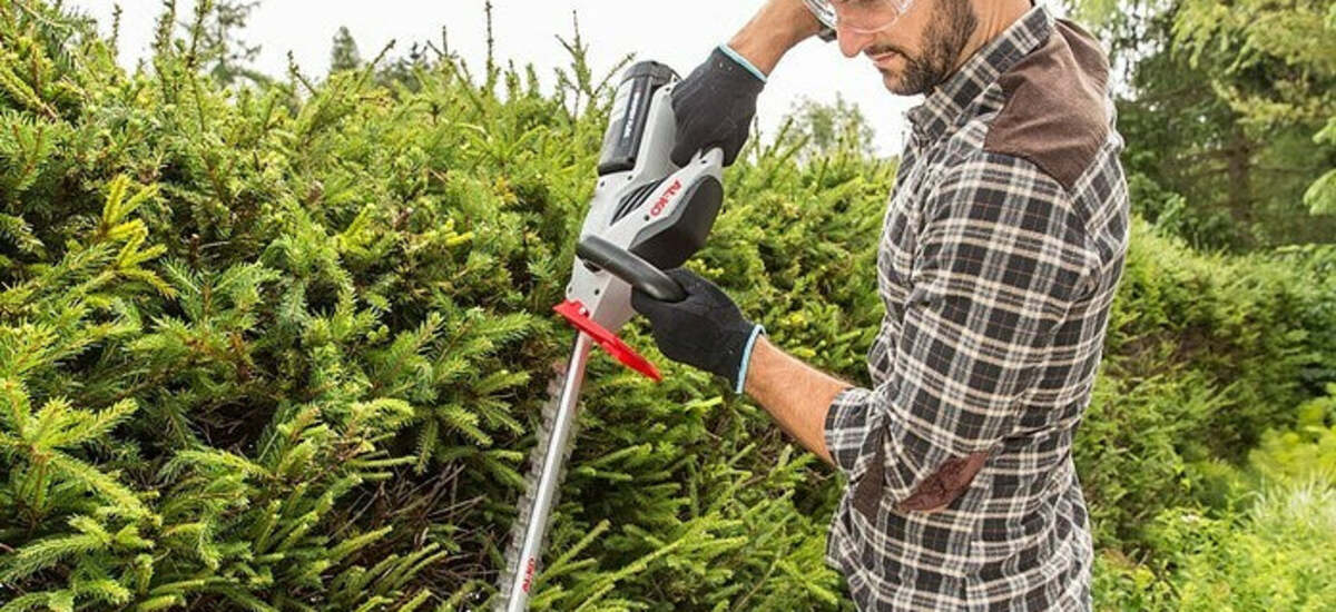 Akku-Heckenschere schneidet eine dichte Hecke im Garten – NIVAROQ