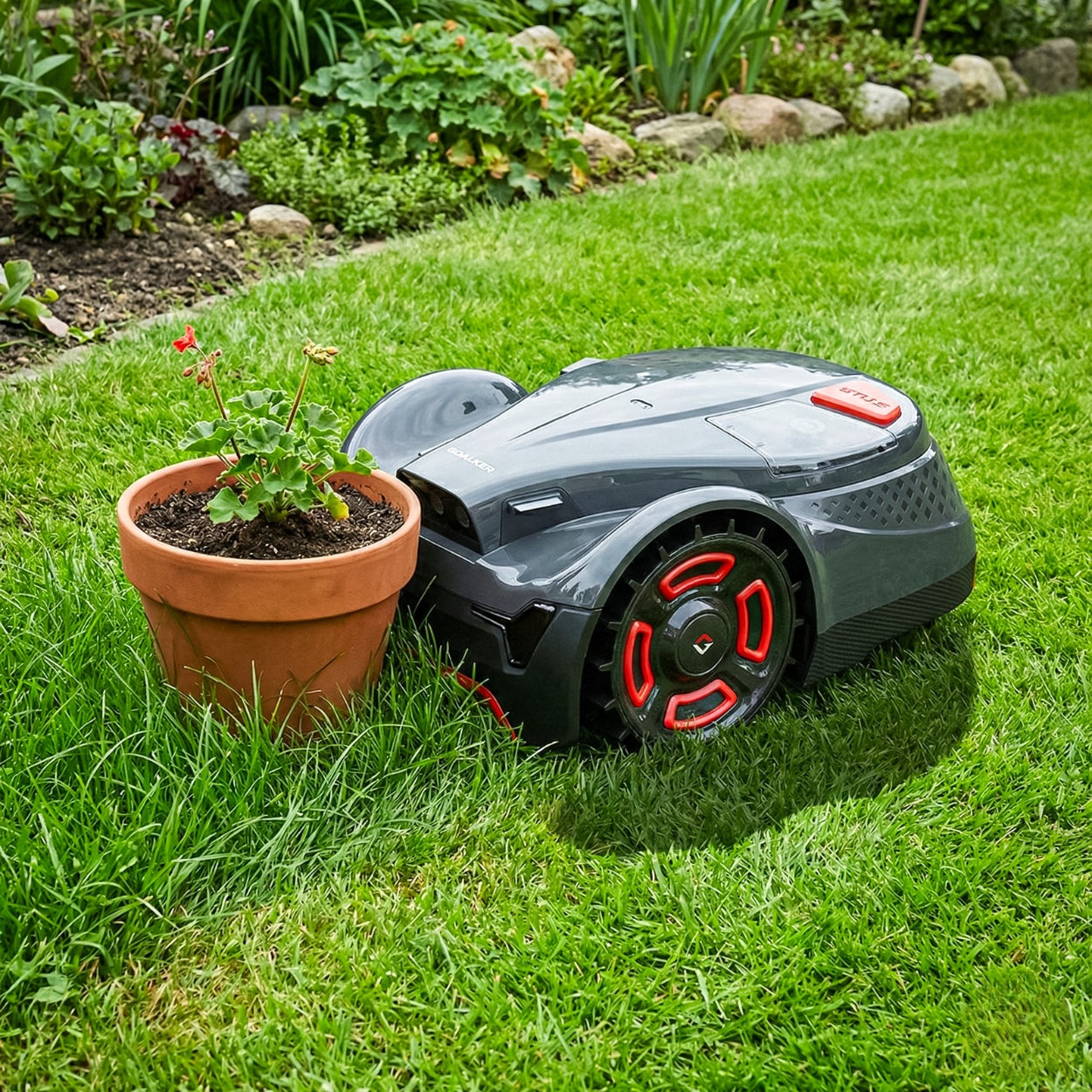 Mähroboter auf Rasen neben Blumentopf, schneidet Gras automatisch im Garten.