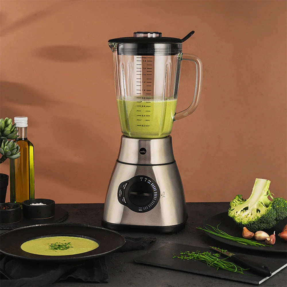 Stand mixer with glass jug filled with green drink and speed dial
